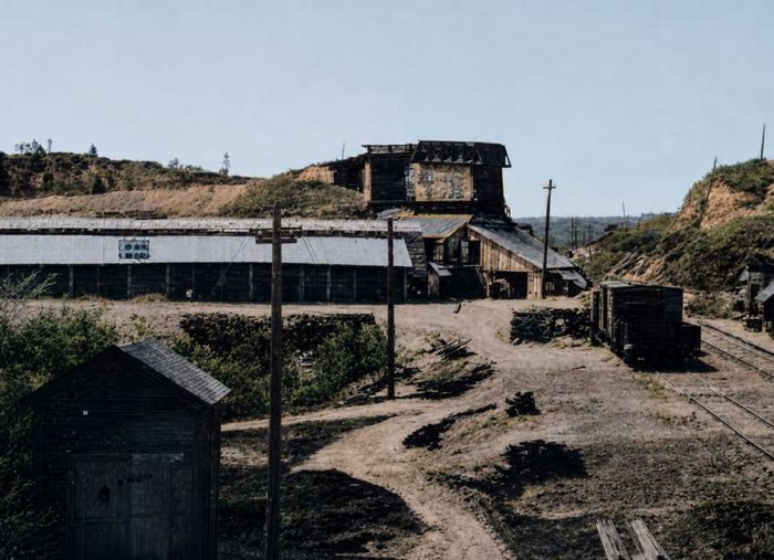 Limehouse. Lime Kilns at the GTR station. 1915. Abandoned rural train yard with wooden storage sheds, rusty rail cars, and dirt paths under a clear sky.